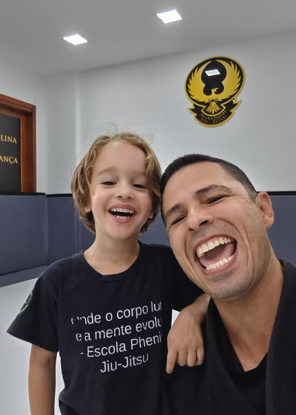 Professor e criança sorrindo depois da primeira aula experimental na Phenix